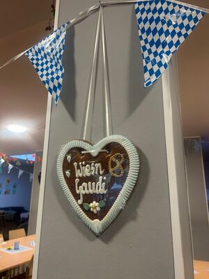 Ein Lebkuchen Herz hängt an der Wand.