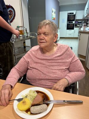 Eine Frau sitzt vor ihrem Essen.