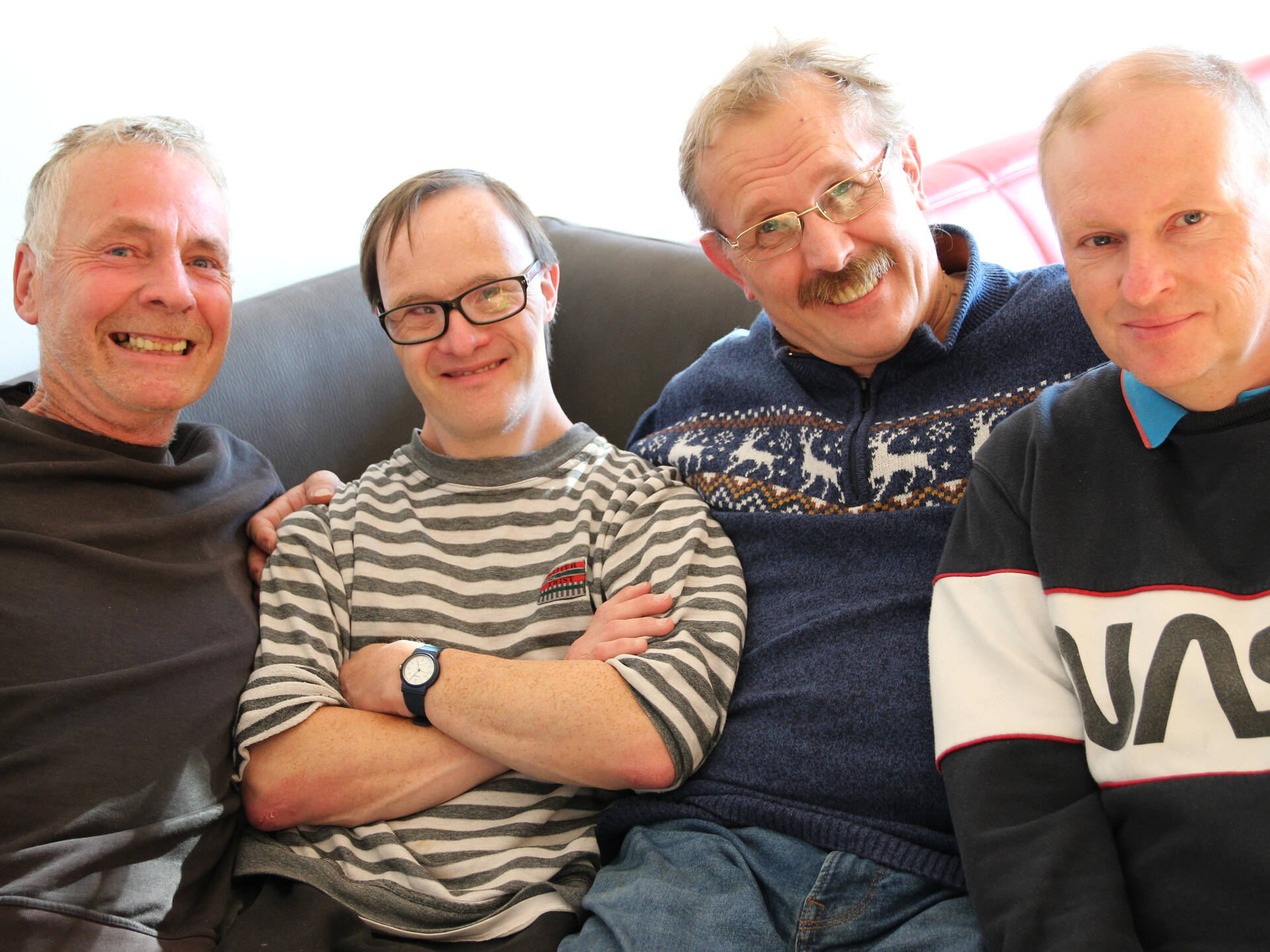 Vier Männer sitzen und lachen