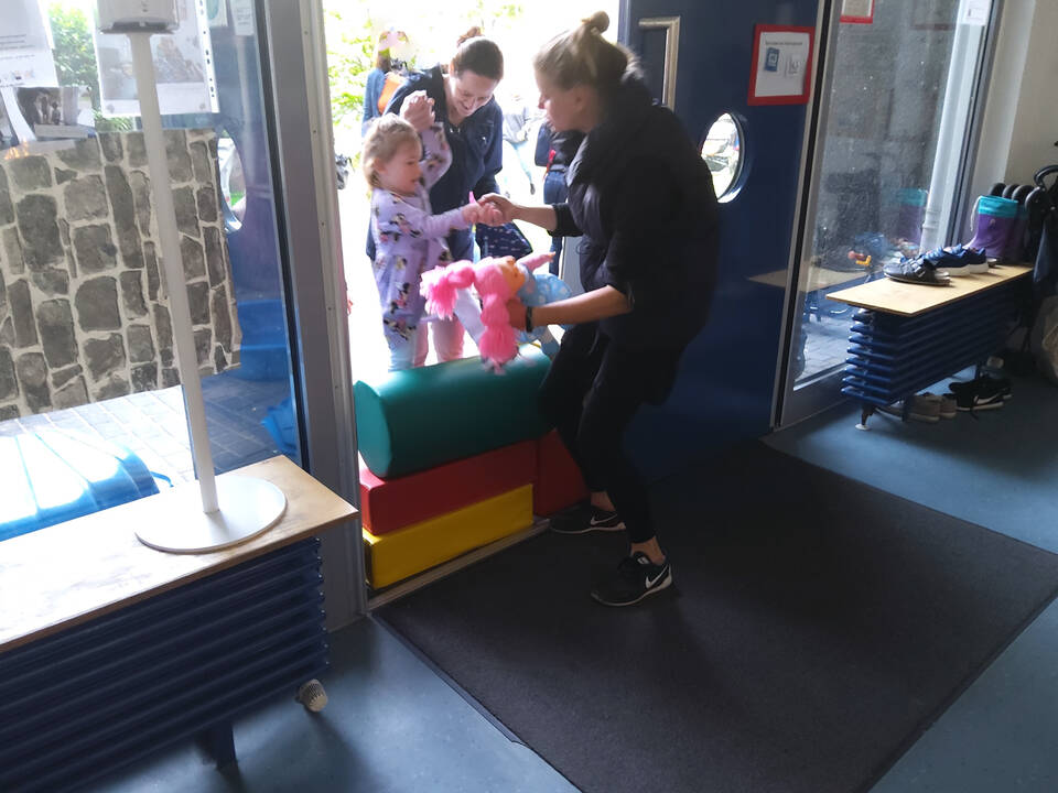 mehrere Kinder und eine Frau stehen in einer Tür gegenüber 