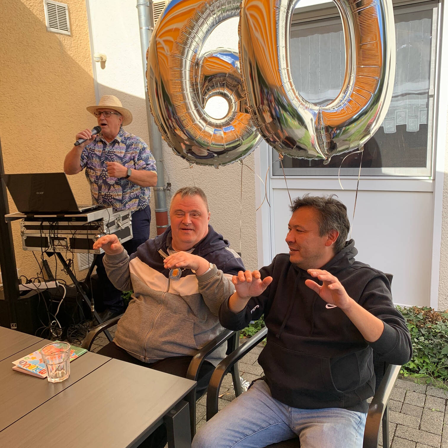 Zwei Personen halten Ballons in Form einer 60.