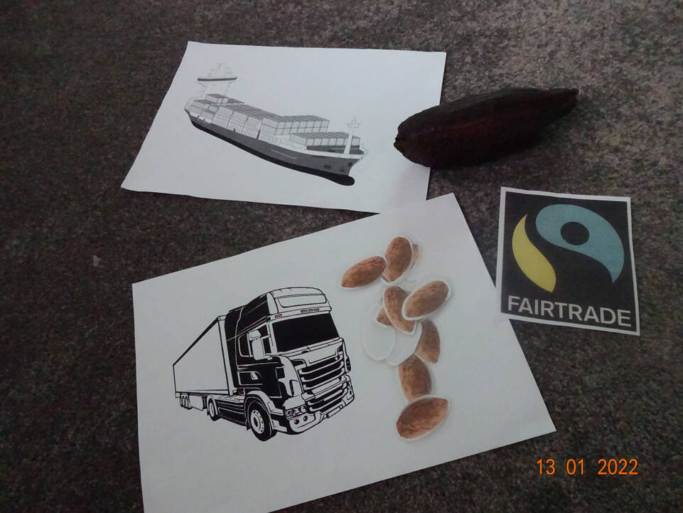 Ein Logo von Fair Trade und jeweils ein Bild mit einem Zug und einem LKW liegt auf dem Boden.
