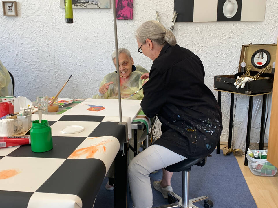 Eine Frau sitzt an einem Tisch und unterstützt.