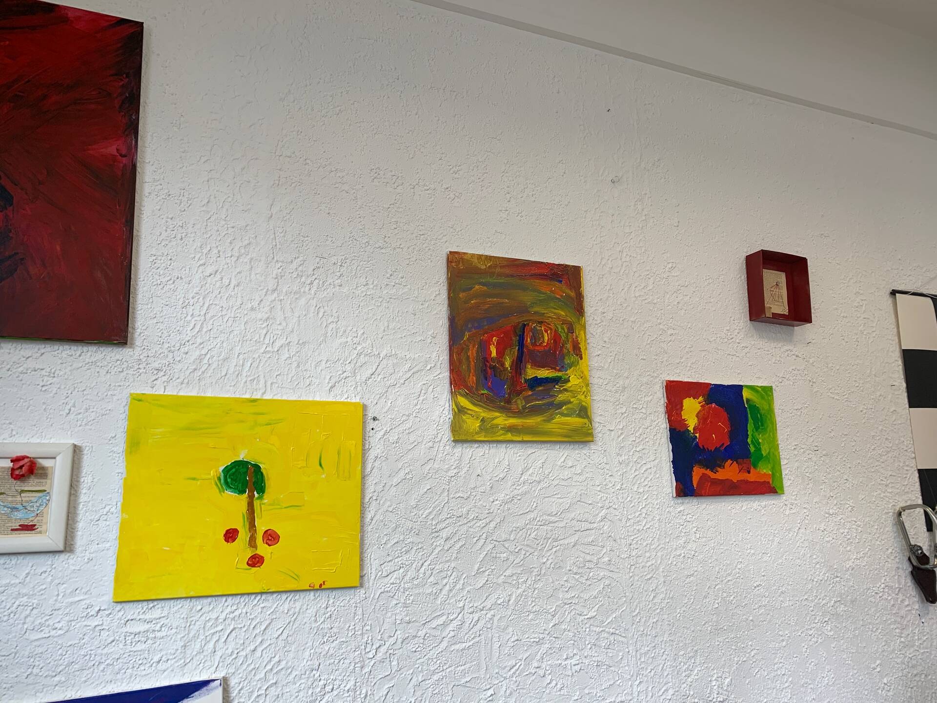 Bilder hängen an einer weißen Wand.