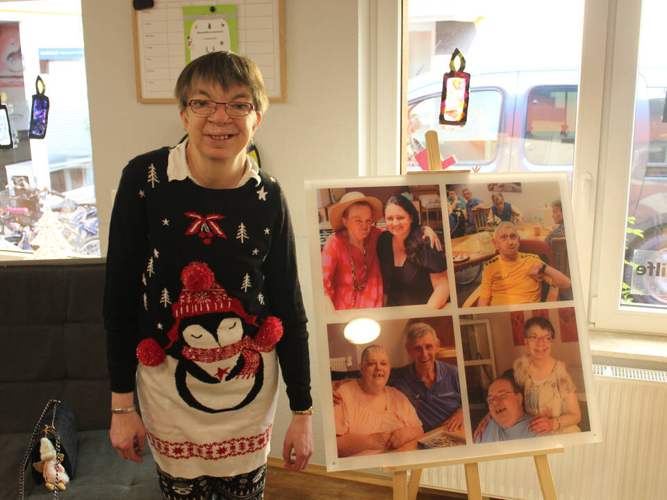 Eine Frau steht neben einem Bild 