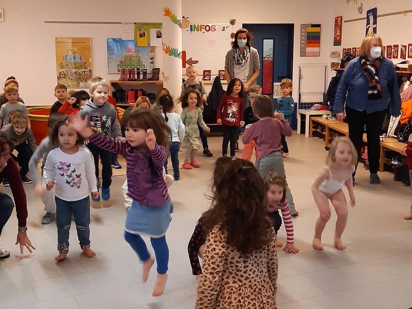 Viele Kinder in Bewegung in einem Raum.