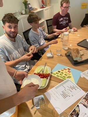 Mehrere Personen sitzen am Tisch und essen.