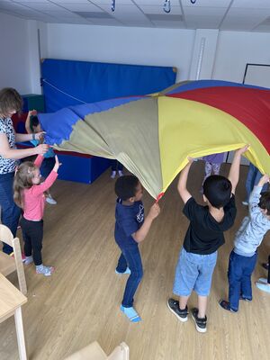 Kinder spielen mit einem Schwungtuch.