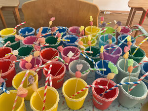 Viele bunte Becher mit Strohalmen.
