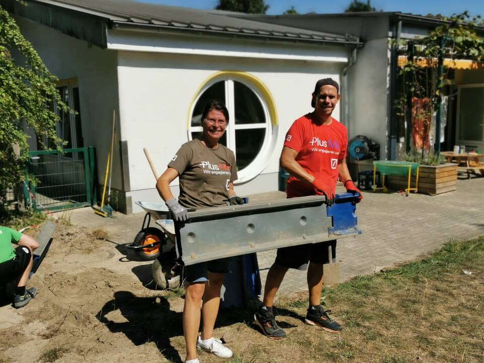 Zwei Personen tragen Metallkörper