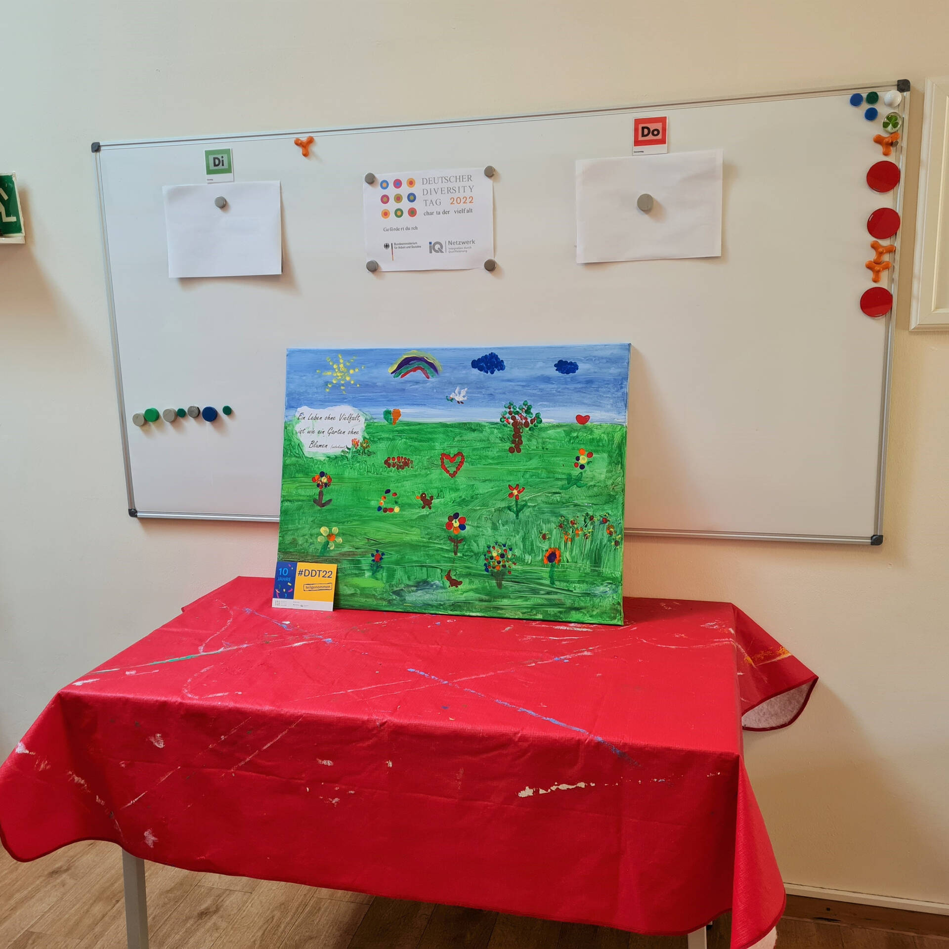 Ein Bild steht auf einem Tisch mit einer roten Decke.