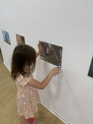 Ein Kind klebt ein Bild an die Wand.