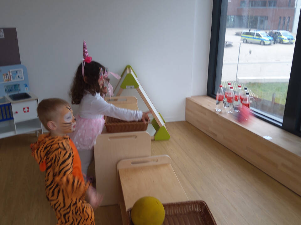 Zwei Kinder beim Dosenwerfen.