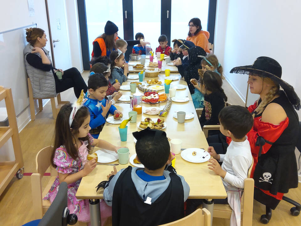 Ein langer Tisch mit vielen Kindern.