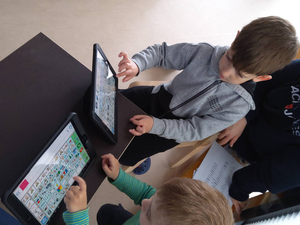 Kinder schauen sich Tablets mit Sprachgesteuerten Systemen an.