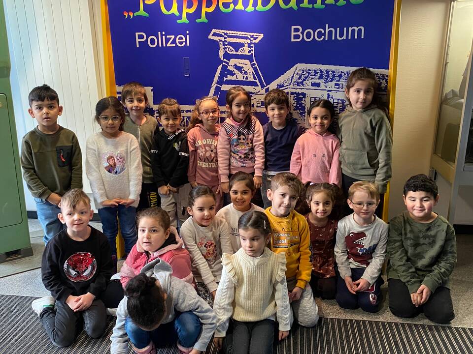 Kinder vor einer großen Werbung der Puppenbühne Bochum