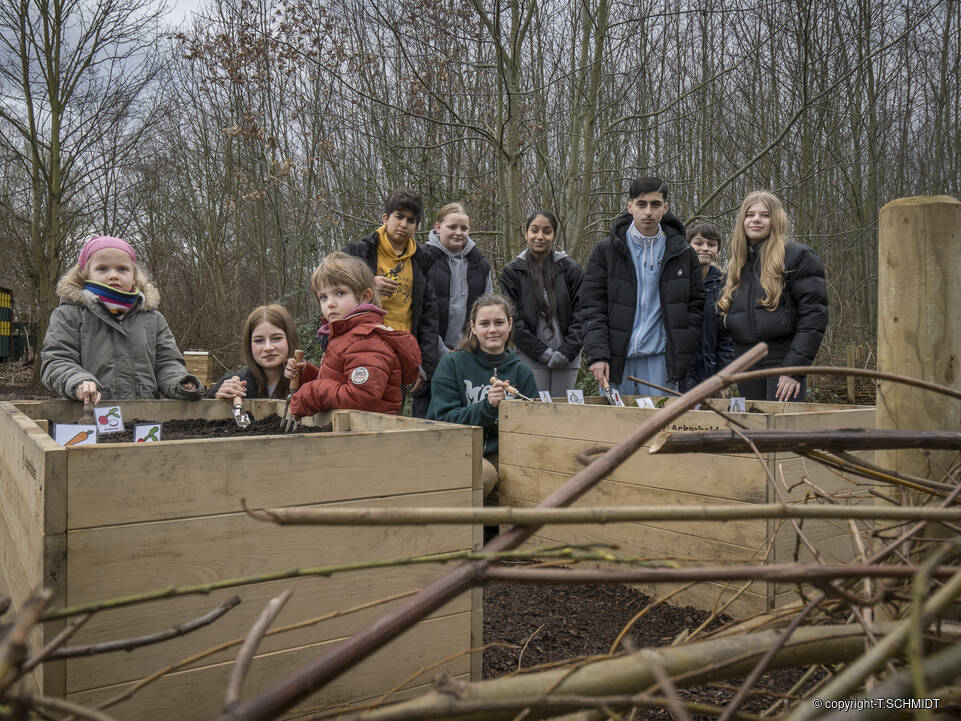 Kinder und Jugendliche an Hochbeeten.