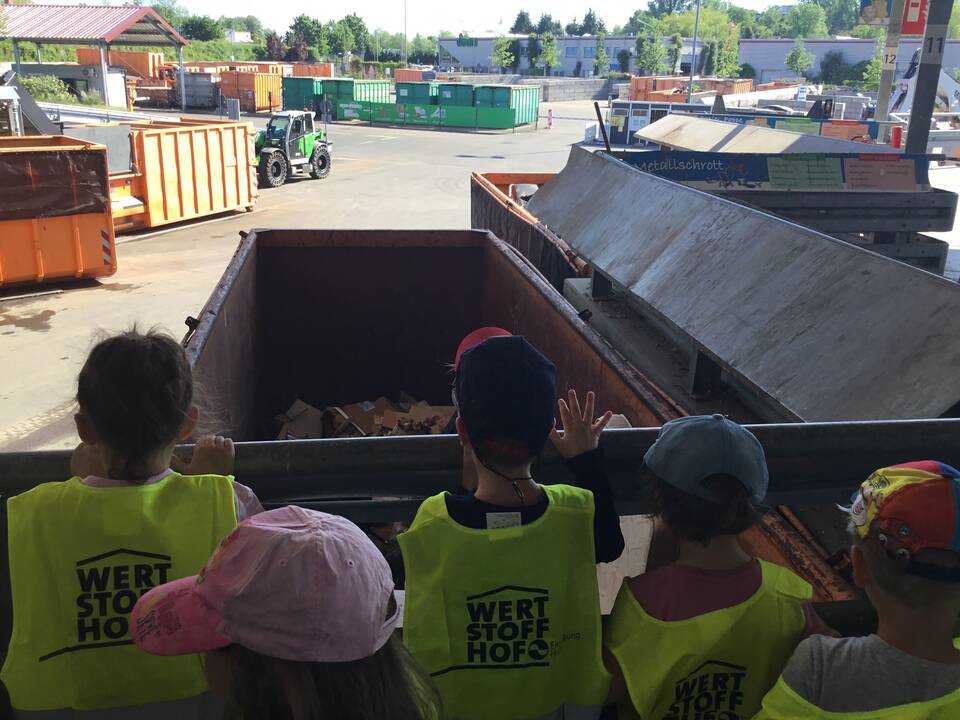 Kinder stehen vor einem großen Container.