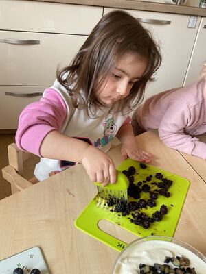 Ein Kind zerkleinert Blaubeeren