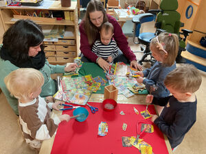 Kinder schneiden aus Prospekten blaue Angebote aus.