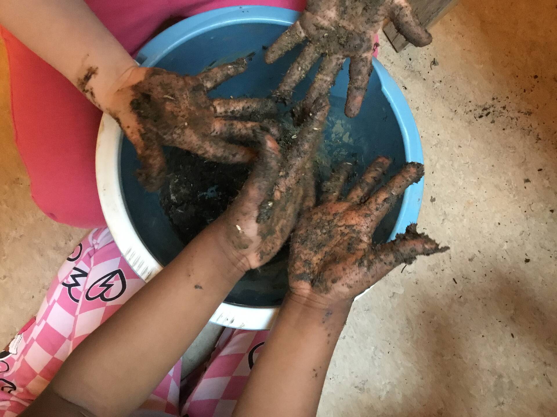 Schmutzige Hände über einer blauen Schüssel.