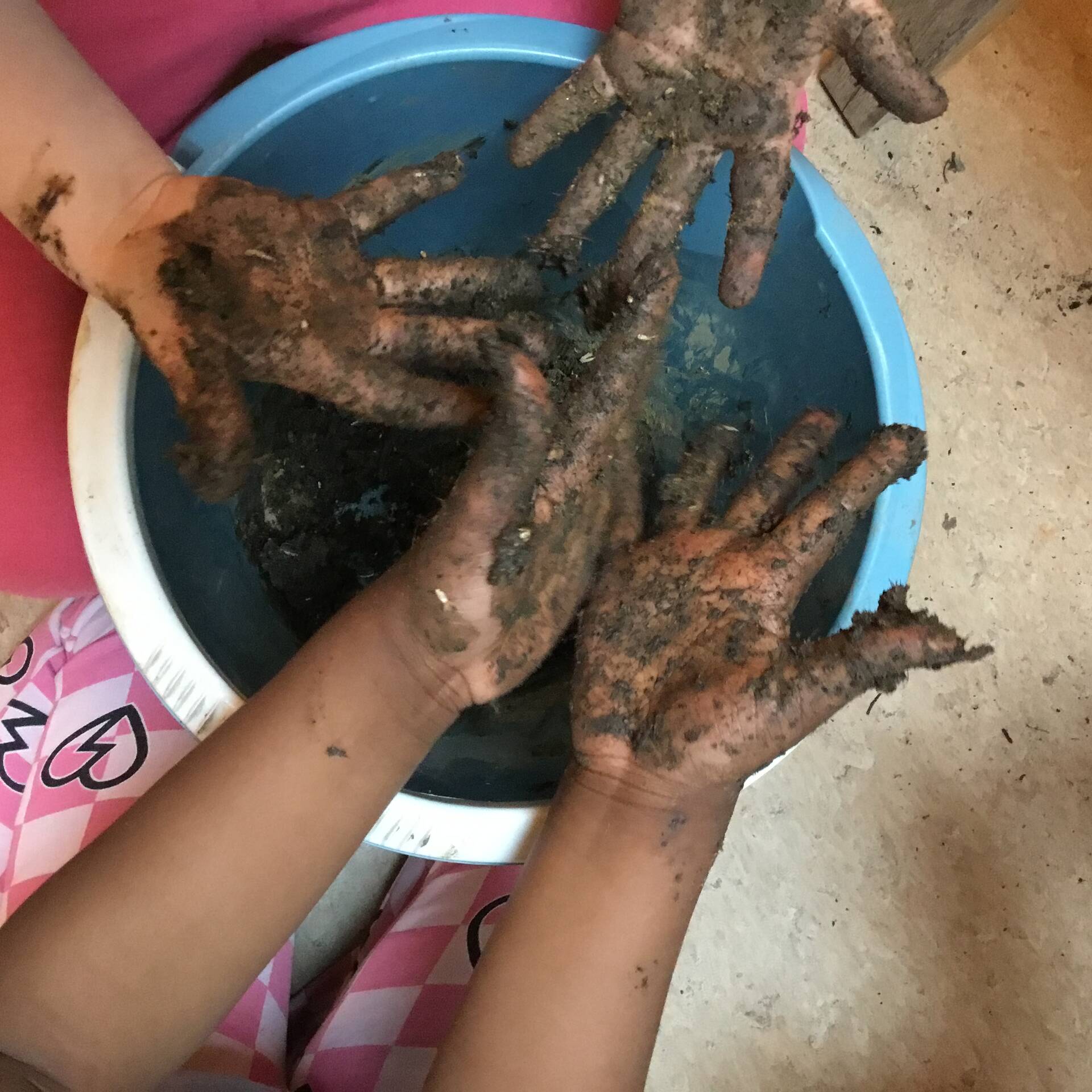 Schmutzige Hände über einer blauen Schüssel.