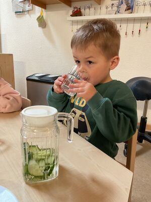 Ein Kind trinkt Gurkenwasser.