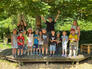 Gruppenfoto der Kinder auf einer Plattform unter einem Baum