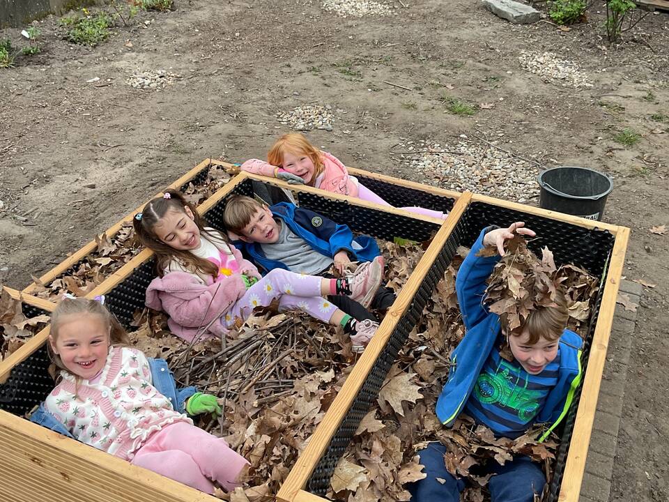 Kinder liegen im neuen Hochbeet.