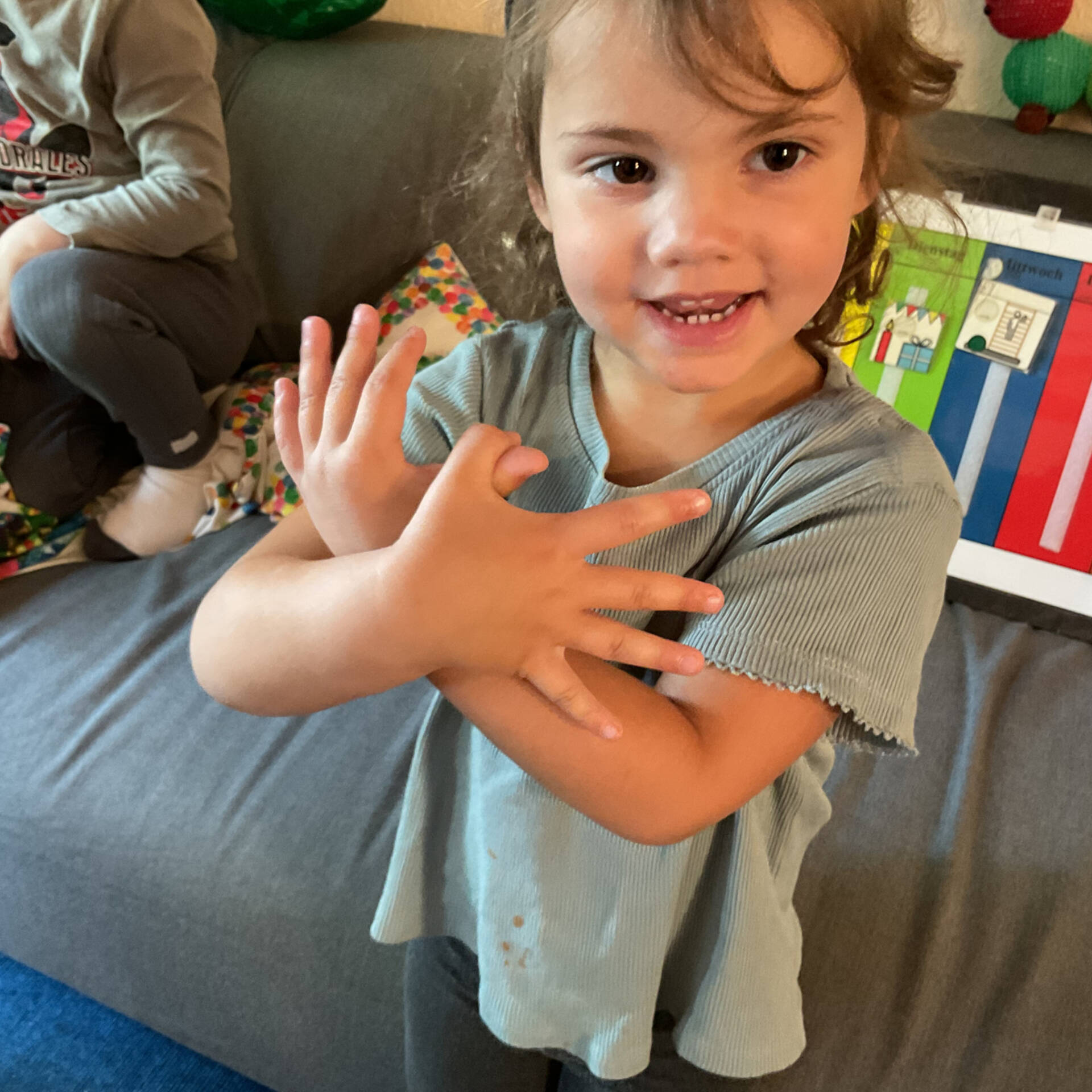 Ein Kind hält seine Arme über Kreuz vor dem Körper