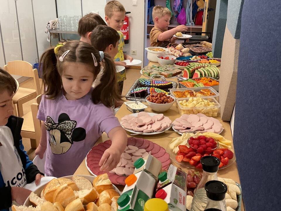 Kinder stehen am Buffet.