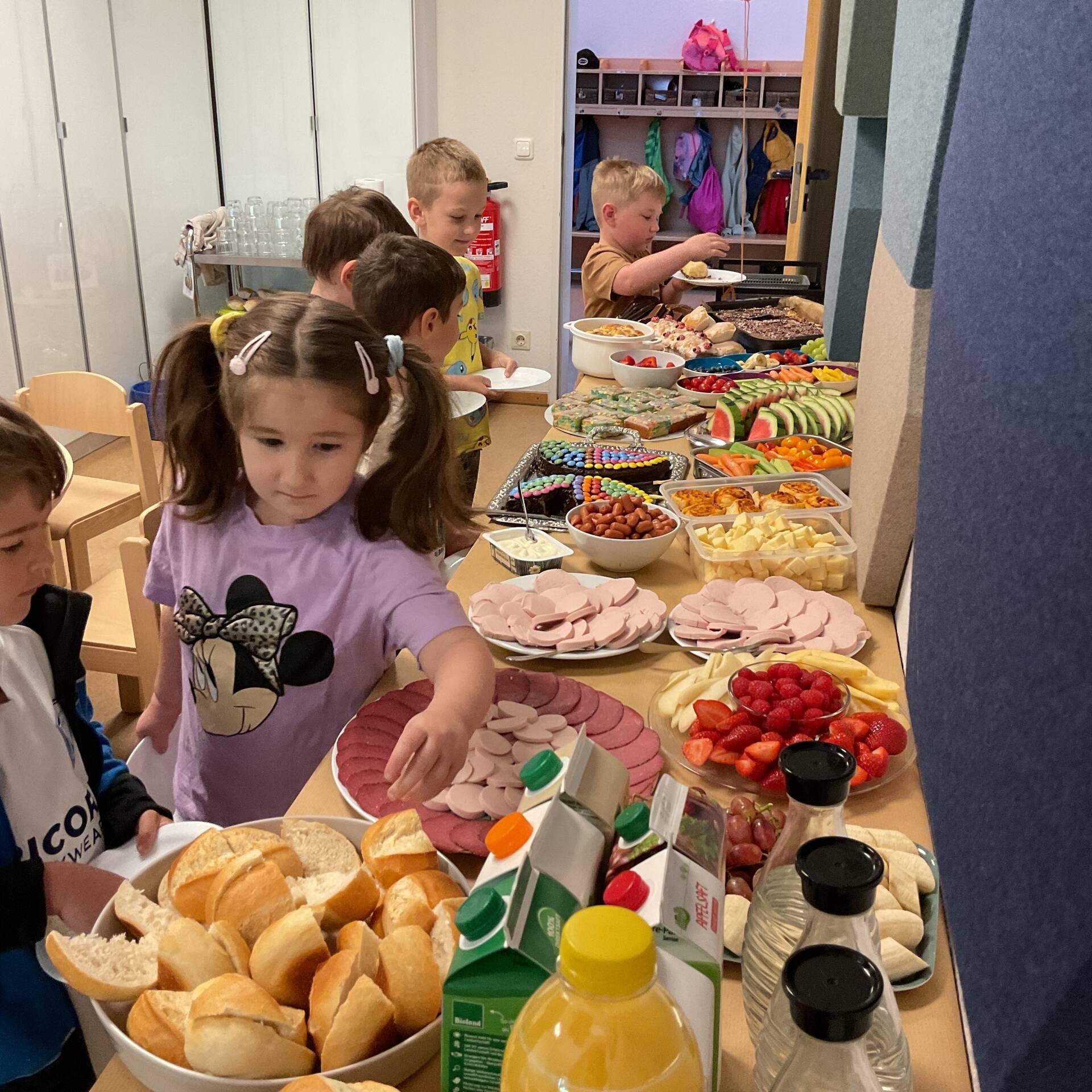 Kinder stehen am Buffet.