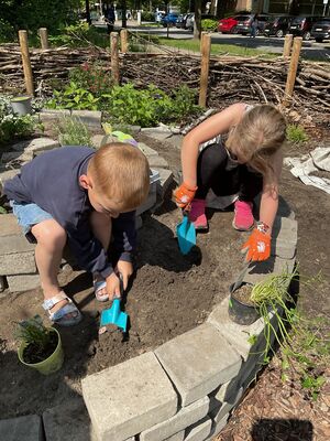 Kinder bepflanzen die Kräuterschnecke.