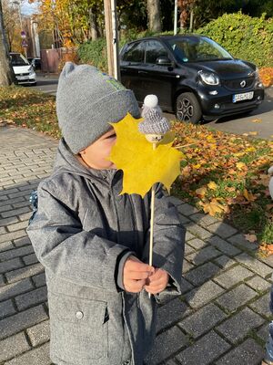 Ein Kind hält ein Stabmännchen in der Hand.