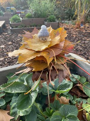 Ein Turm mit Blätter mit einem Holzkopf oben drauf.