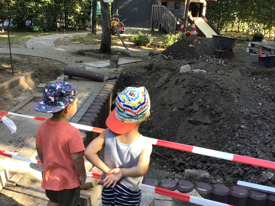 Zwei Kinder schauen auf die Baustelle