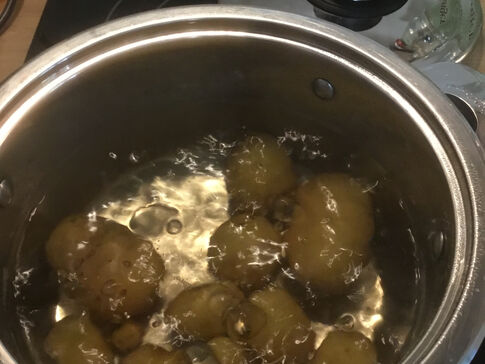 Kartoffeln in einem Topf mit Wasser auf einem Herd.