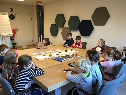 Kinder zusammen am Tisch beraten.