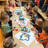 Kinder sitzen am gedeckten Tisch und essen Muffins.