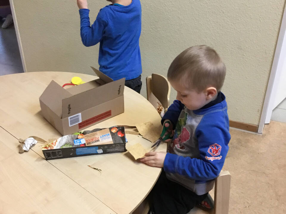 Kinder zerschneiden Pappe