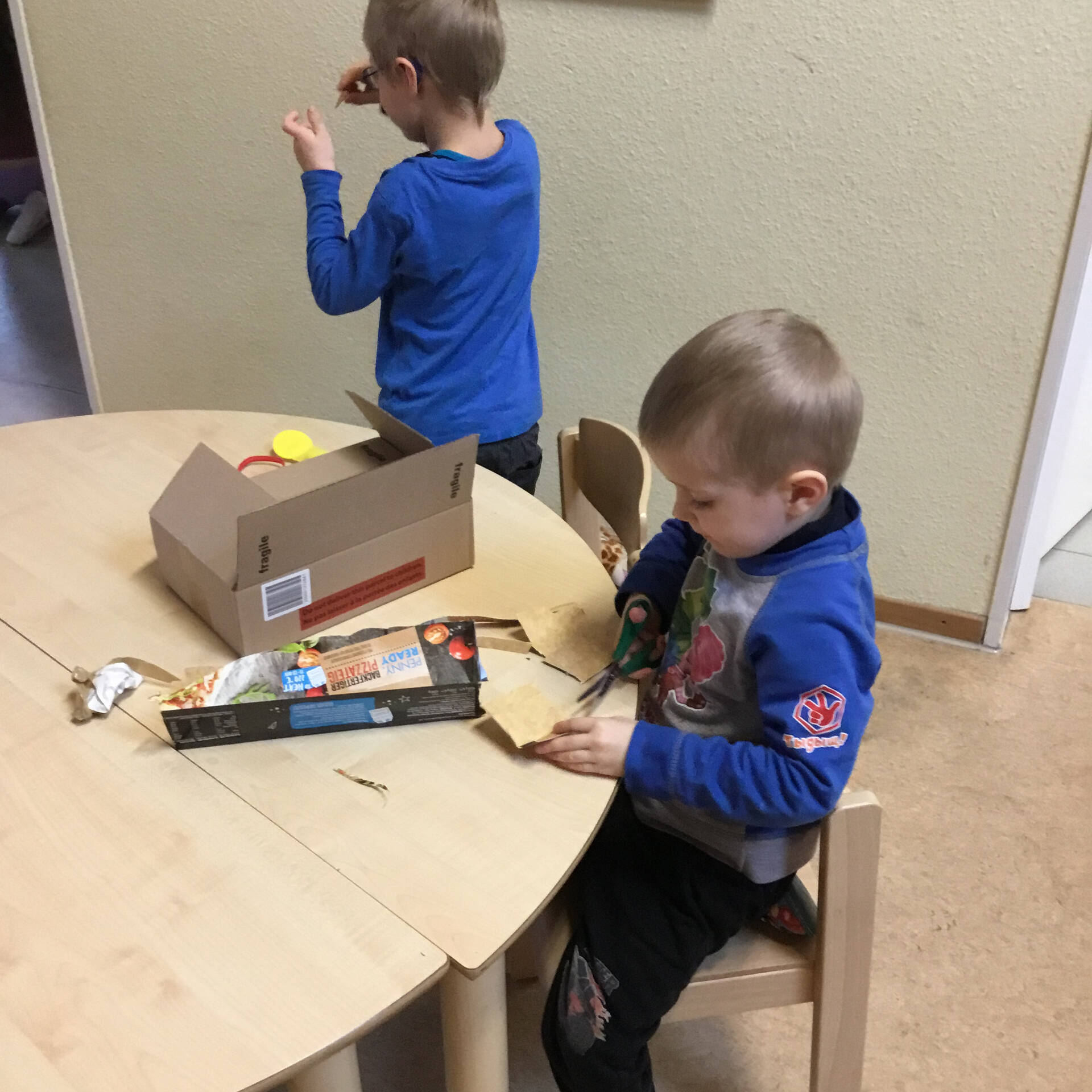 Kinder zerschneiden Pappe