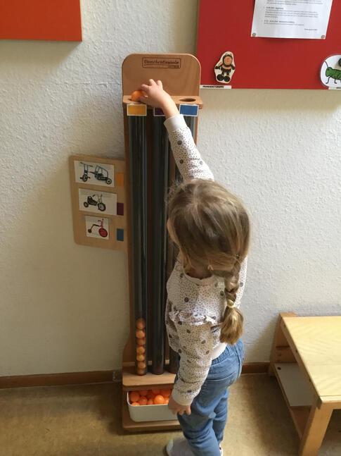 Ein Kind steht vor einer Säule der der Abstimmung dient.