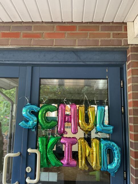 Es steht Schulkind geschrieben aus Luftballons an einer Tür.