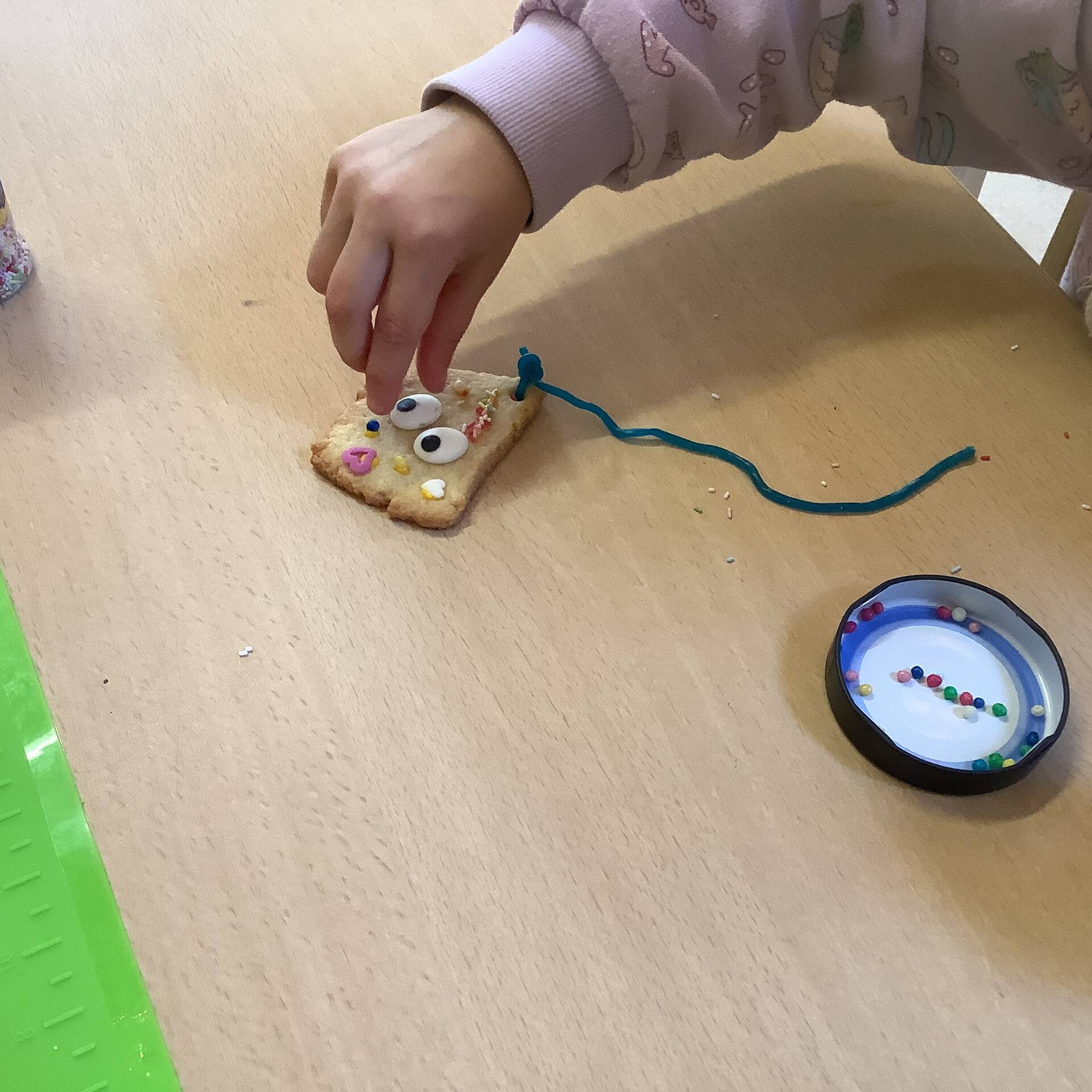 Eine Hand verziert ein Plätzchen