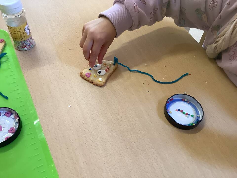 Eine Hand verziert ein Plätzchen