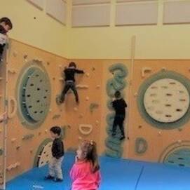 Kinder klettern an einer Kletterwand