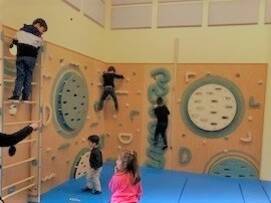 Kinder klettern an einer Kletterwand