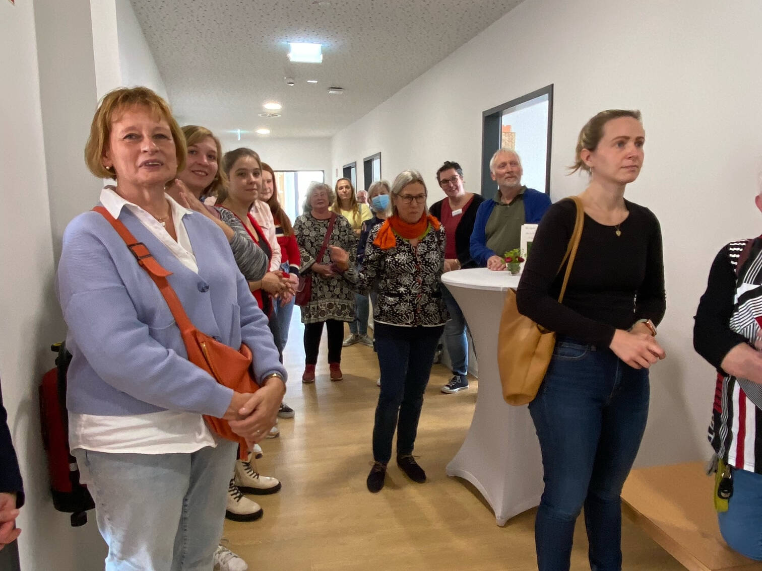 Vielke Personen stehen in einem Flur.