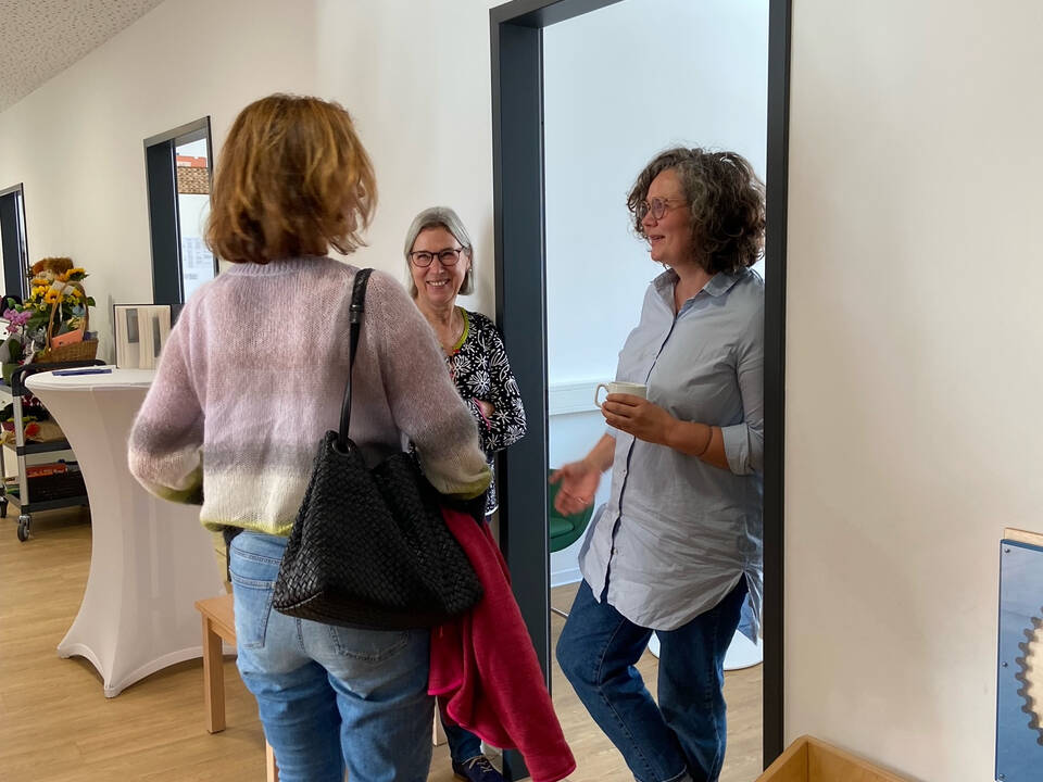 Mehrere Personen hören einer Frau zu.