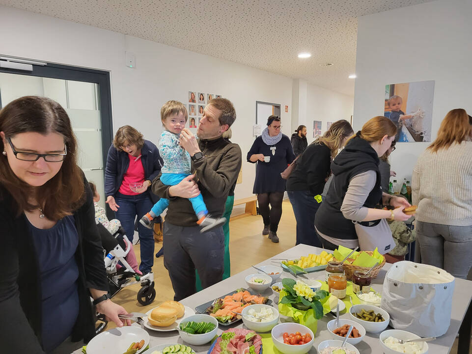 Viele Menschen in einem Raum am Buffet.